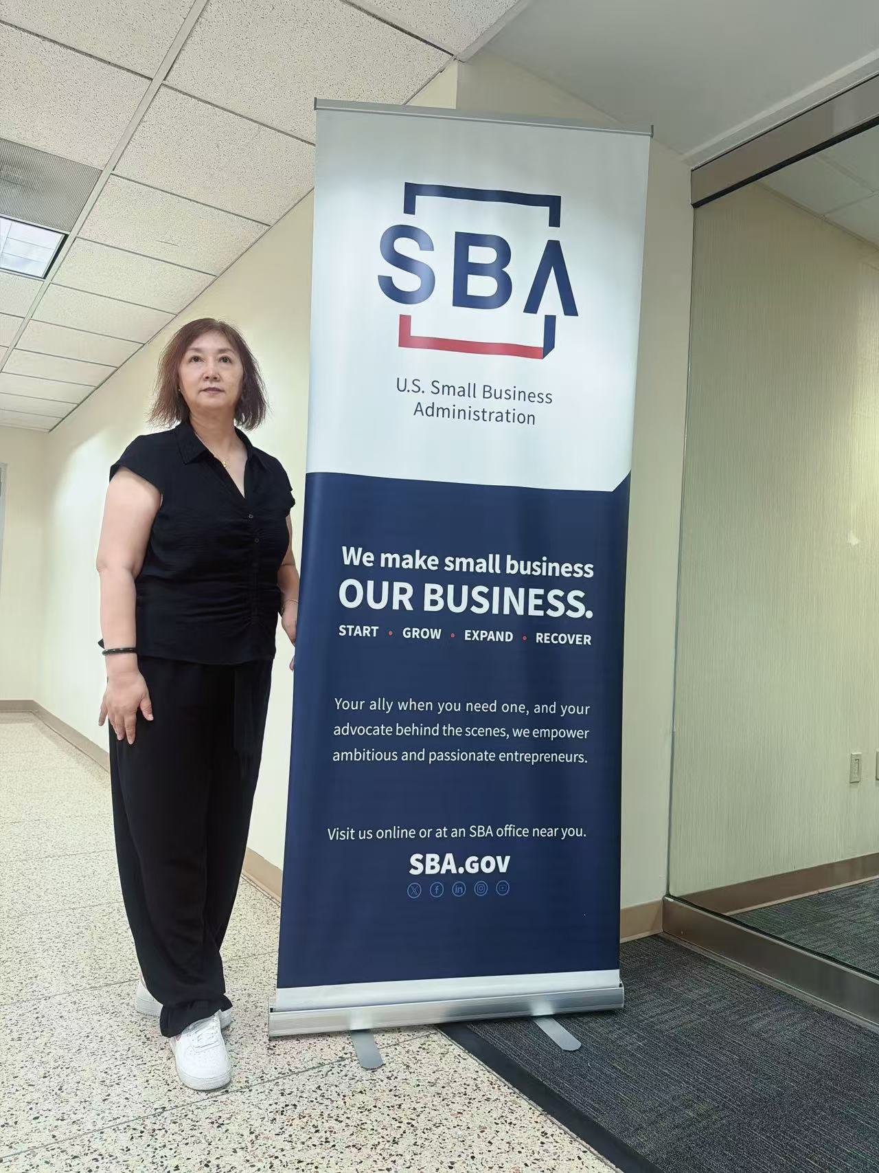 华人女性会员在美国联邦小企业局 SBA 展架旁留影